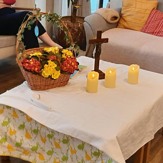 Demenz-Andacht in Haus Schwabachauen in Buckenhof, Tisch mit Kreuz, Kerzen und Blumen