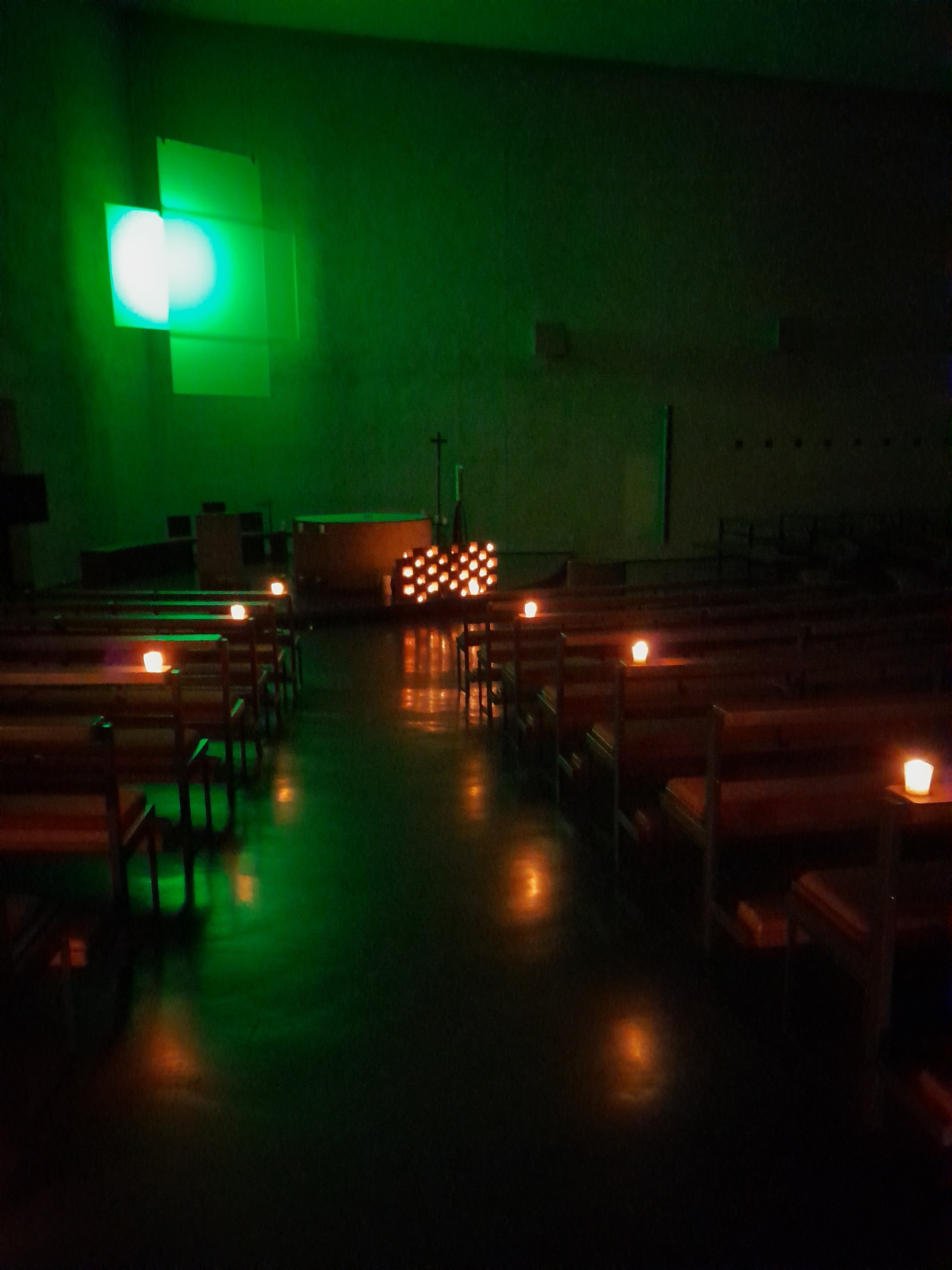 beleuchtetes Kreuz, Kirche bei Kerzenschein